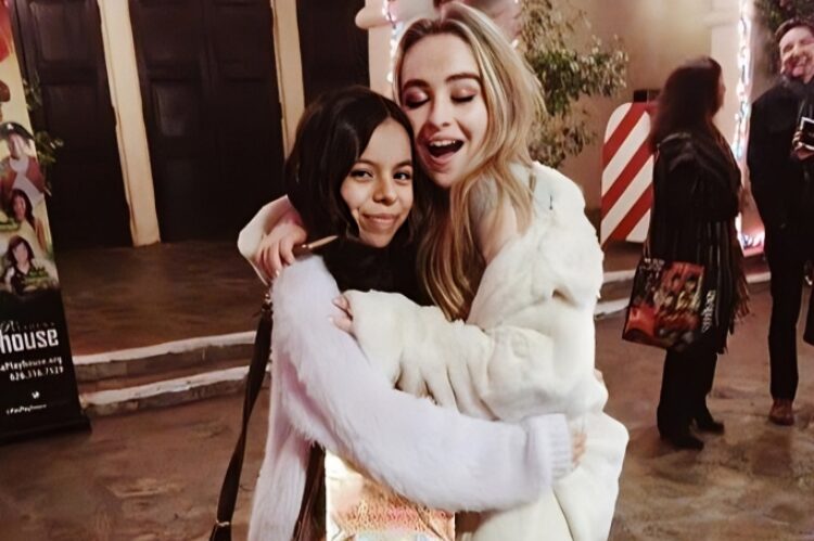 A group of young fans dressed in Sabrina Carpenter-inspired outfits — taking selfies outside a concert venue.