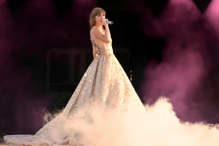 A radiant champagne-colored sparkle dress displayed under golden stage lights.