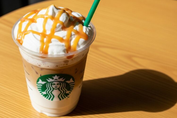 A tall Starbucks iced drink with fluffy white cloud foam and caramel drizzle.