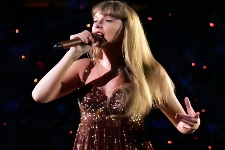 Taylor Swift performing in a bold bronze-gold mini dress