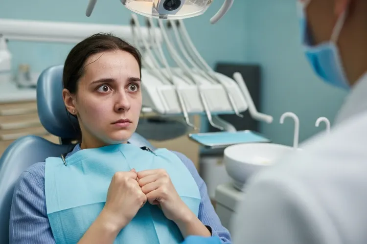 A woman nervously sitting in a dentist’s chair.