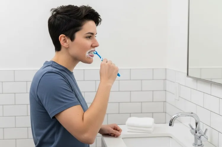 A woman brushing teeth correctly using a soft-bristled toothbrush.