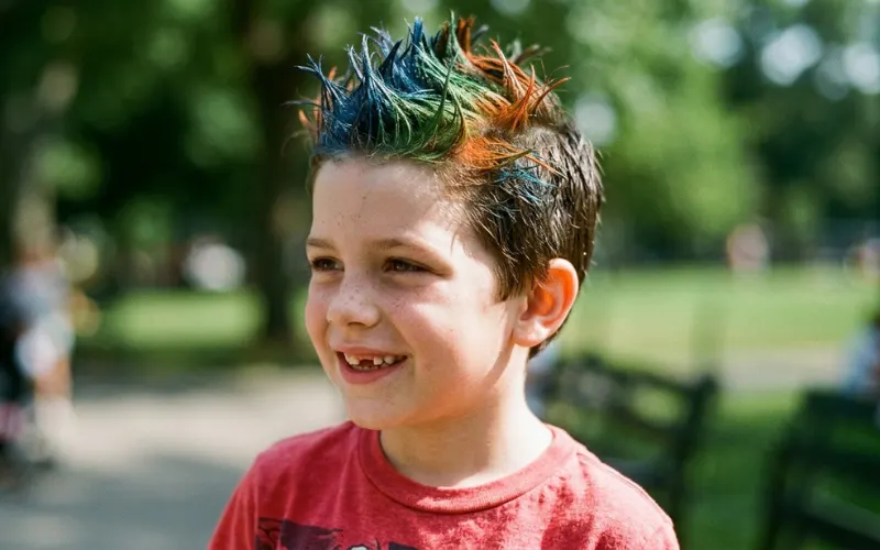 “child with short spiky gelled hair and bright color spray, close-up, realistic texture, sharp lighting”