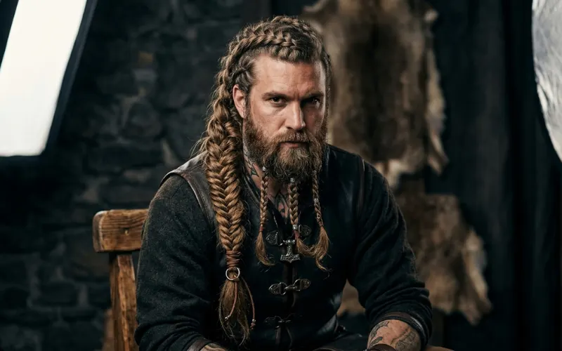 Different Viking braid styles on male model, side braid, crown braid, beard braids, studio lighting.