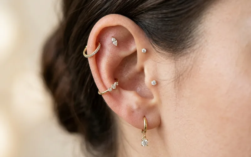 Close-up of stylish ear piercings with elegant jewelry.
