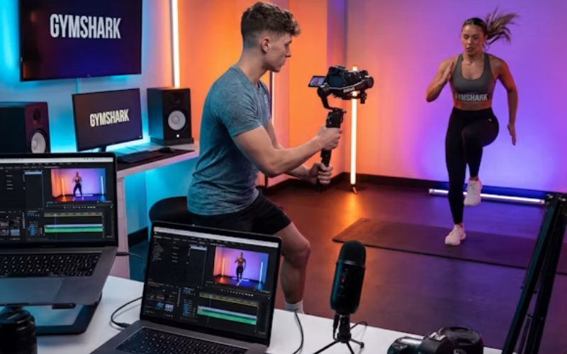 Professional fitness video production with a creator recording workout content in a studio.
