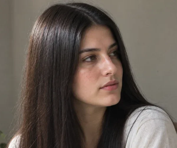 Woman with sleek straight type 1 hair sitting indoors, showcasing 1A, 1B, 1C hair type texture.