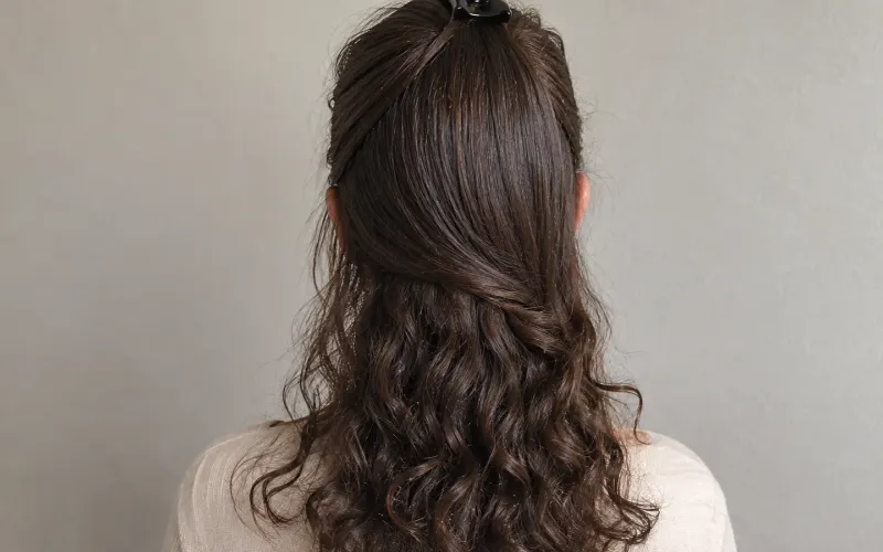 Woman with long dark brown irish curly hair, back view.