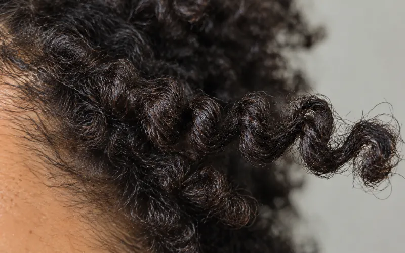 Extreme close-up of a tightly coiled curl against the scalp.